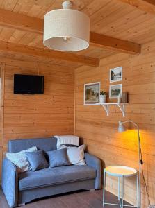 a living room with a blue couch in a wooden wall at Apartamenty & Domek Gawędówka in Krościenko