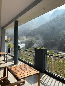a balcony with a bench and a view of a mountain at Amritganga Homestay in Uttarkāshi