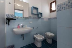 a white bathroom with a sink and a toilet at Il Torrazzo da Francesca in San Vito lo Capo