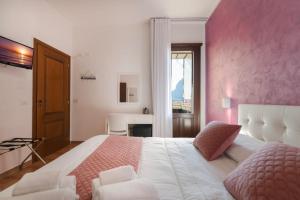 a bedroom with a large bed with a pink wall at Il Torrazzo da Francesca in San Vito lo Capo