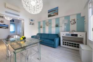 a living room with a blue couch and a glass table at Smeraldo in Palau