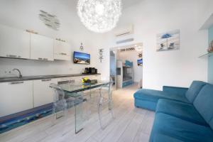 a kitchen and a living room with a blue couch at Smeraldo in Palau +6 photos