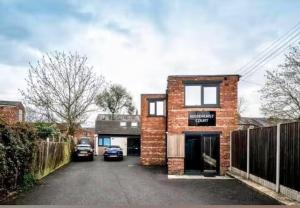 a brick house with a car parked in a driveway at Stylish Loft in Stockport - Free Parking - 10 min to Manchester - Flat 1 in Stockport