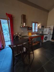 a kitchen with a table and chairs in a room at Maison individuelle, au calme in Visan