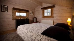 a bedroom with a bed and two windows at Gîtes du vrai monde in Fillinges