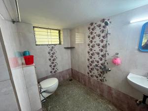a bathroom with a toilet and a sink at Lake View in Kundapur