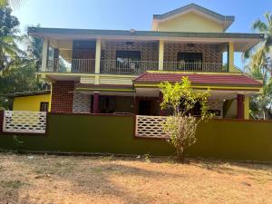 a house with a green fence in front of it at Lake View in Kundapur