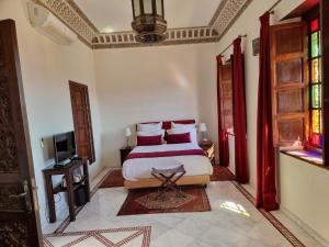a bedroom with a bed and a tv in it at Riad Batchisarai in Fez