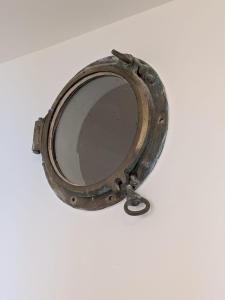 an old mirror sitting on a white surface at Back in Tide , frontal sea view window, no AC, Pet friendly in Riomaggiore