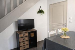 a living room with a table and a tv on a dresser at Résidence Les Demeures du Ventoux in Aubignan
