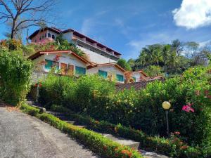 a house on the side of a hill with flowers at Hotel Las Brisas del Pacifico in Sámara