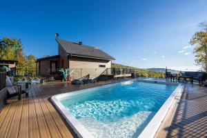 a large swimming pool on a wooden deck at Käbane Miramar - L'Oasis du Fleuve in Les Éboulements