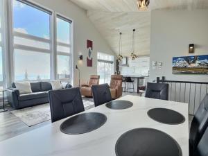 a kitchen and living room with a table and chairs at Käbane Miramar - L'Oasis du Fleuve in Les Éboulements
