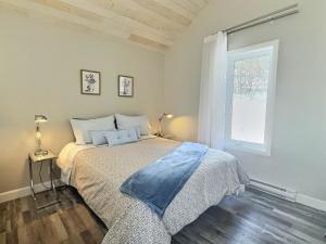 a bedroom with a bed and a window at Käbane Miramar - L'Oasis du Fleuve in Les Éboulements +20 photos
