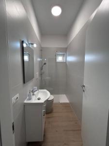 a white bathroom with a sink and a toilet at Nuvola Hosting in Segrate