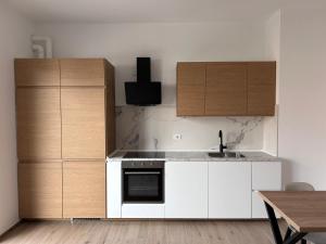 a kitchen with white counters and wooden cabinets at Nuvola Hosting in Segrate