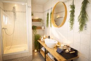 a bathroom with a sink and a mirror and a tub at Ringdays Guesthouse in Müllenbach +45 photos