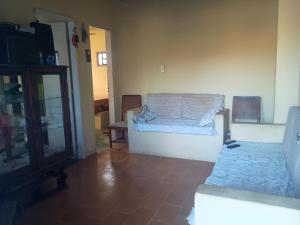 a living room with a bed and a mirror at Casa em Araruama com 3 quartos e muito arejada in Araruama