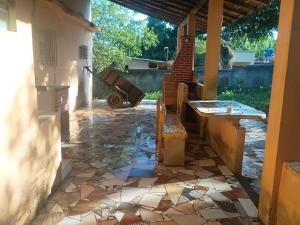 a patio with a stone floor and a wheelbarrow at Casa em Araruama com 3 quartos e muito arejada in Araruama