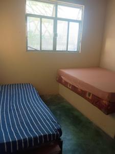 a room with two beds and a window at Casa em Araruama com 3 quartos e muito arejada in Araruama +20 photos