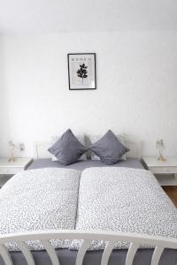 a bedroom with a white bed with a picture on the wall at Ferienwohnung LAZ am Dreiländereck in Bad Säckingen