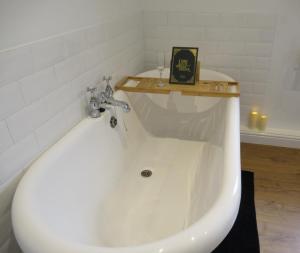 a white bath tub in a bathroom with a shelf at Cosy stylish house West Hull in Hull +32 photos