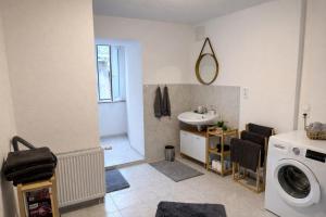 a bathroom with a washing machine and a sink at Ferienwohnung LAZ am Dreiländereck in Bad Säckingen