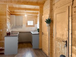 a kitchen with wooden walls and a wooden door at Wind Hall Log Cabin in Gosforth
