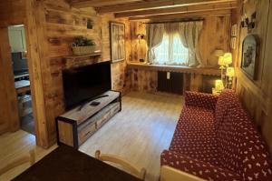ein Wohnzimmer mit Sofa und Flachbildfernseher in der Unterkunft Hotel Letterario Locanda Collomb in La Thuile