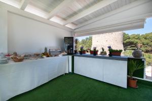 a kitchen with white counters and a large window at Il Torrazzo da Francesca in San Vito lo Capo