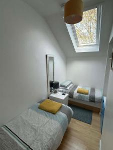 a bedroom with two beds and a mirror and a window at 20 Strawberry Hill cosy cottage sleeps 5 in Hayle +22 photos
