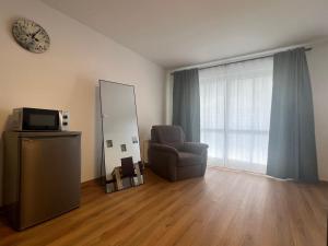 a living room with a chair and a mirror at Apartment Sebald in Ingolstadt