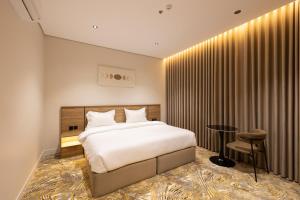 a hotel room with a bed and a table and a chair at فندق أجنحة رواق in Medina