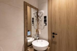 a bathroom with a white sink and a mirror at فندق أجنحة رواق in Medina +27 photos