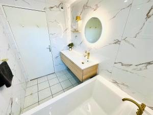 a white bathroom with a tub and a sink at L' Évéa Rooftop in Le Relecq-Kerhuon +39 photos