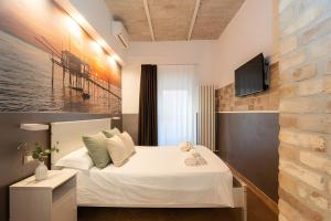 a bedroom with a bed and a tv on a wall at Heart of Pescara Elegant Suites - Chic Suites in Pescara Center & 2 steps from Sea - AC & Wifi in Pescara