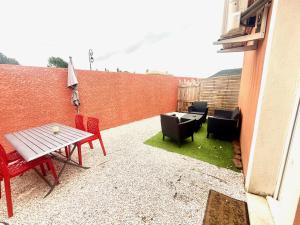 a patio with a table and chairs and a fence at Studio indépendant près Salagou in Le Bosc