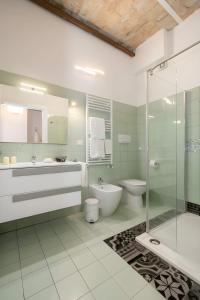 a bathroom with a toilet and a sink and a shower at Heart of Pescara Elegant Suites - Chic Suites in Pescara Center & 2 steps from Sea - AC & Wifi in Pescara +13 photos