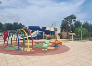a playground with a slide in a park at Au Valras plage in Sérignan