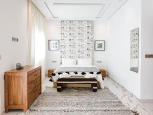 a bedroom with a bed and a dresser at Villa Africa in Essaouira