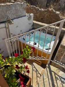 a balcony with a bed and flowers on the stairs at Villa Kastrouna, with private heated jacuzzi in Symi