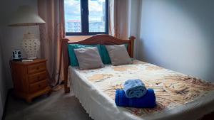 a bedroom with a bed and a window and a night stand at Le Verger Sur Mer in Flic-en-Flac