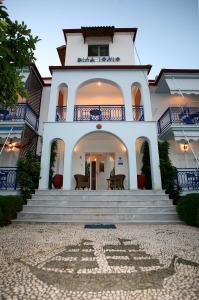 a large white house with stairs and a balcony at Ionio Gastronomy Suites in Ammoudia