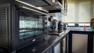 a kitchen with a microwave oven on a counter at Le Verger Sur Mer in Flic-en-Flac
