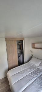 a bedroom with a large white bed in a room at Monpetitmobilhome in Ascarat