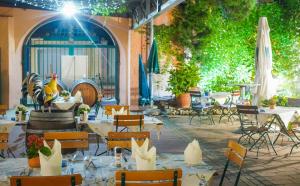 a restaurant with white tables and chairs and trees at Kaiserstühler-Hof in Breisach am Rhein