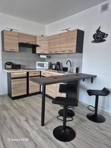 a kitchen with a table and two bar stools at Apartament Bieszczady in Myczkowce