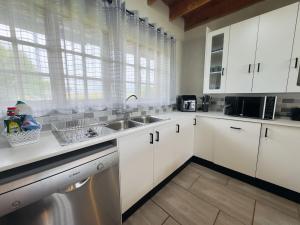 a kitchen with white cabinets and a sink at Vaal Dam Getaway in Denysville