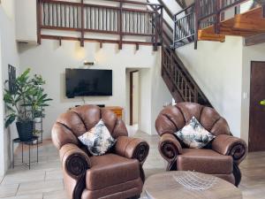 two leather chairs and a table in a living room at Vaal Dam Getaway in Denysville