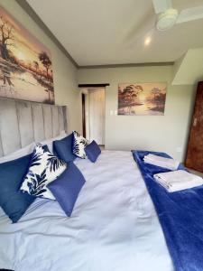 a large bed with blue and white pillows on it at Vaal Dam Getaway in Denysville +21 photos